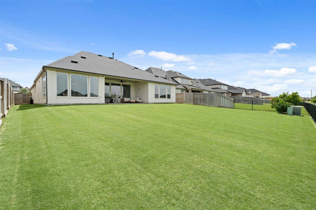Despite the covered patio, this poolsized backyard still offers plenty of  green space for children to play, pets  to roam, or for you to cultivate your  very own garden oasis.