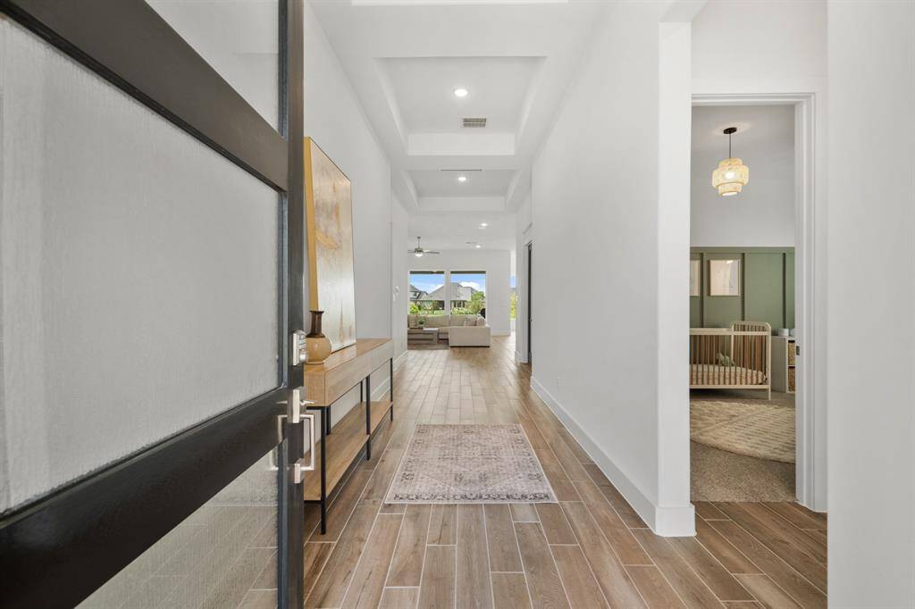 Step inside to sweeping Vicinity 6x36 tile flooring in a natural finish, laid in a random linear pattern for a sophisticated touch. Soaring ceilings and designer-curated paint colors create a light-filled, grand entry that sets the tone for the elevated elegance found throughout the home.