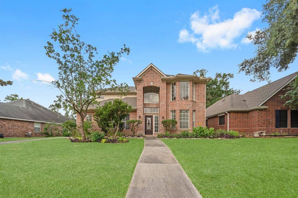 2 story brick house with detached garage. (Grass being virtually staged)