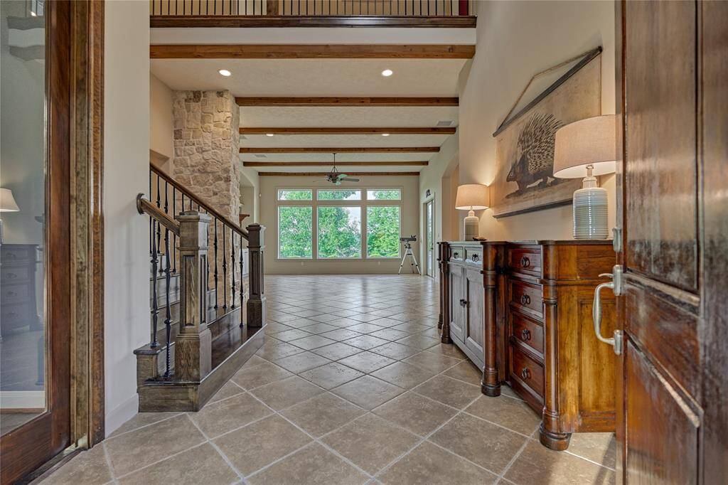 Step into a beautiful foyer and immediately notice the eye catching picture windows and elegant faux wood beams.