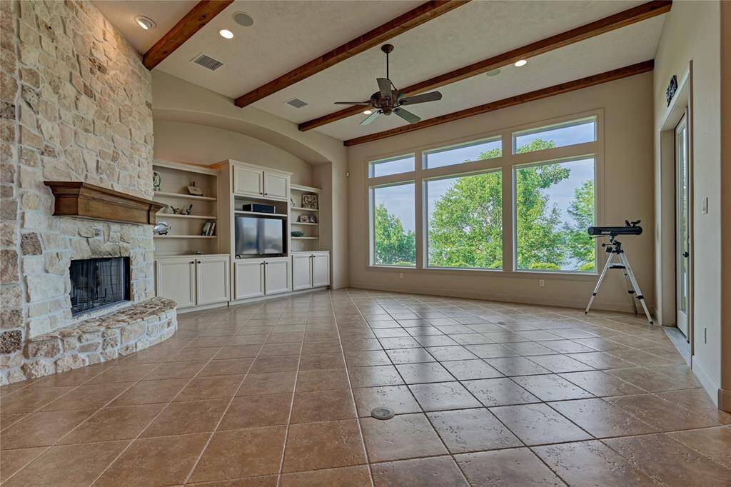 The family room is flooded with natural light through the wall of windows and features custom built-in storage.