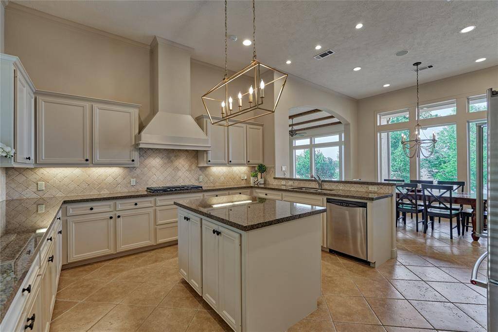 This impressive island kitchen boasts of solid wood cabinetry, stainless steel appliances, granite counters, an ice maker, wine fridge and a 5-burner gas range.