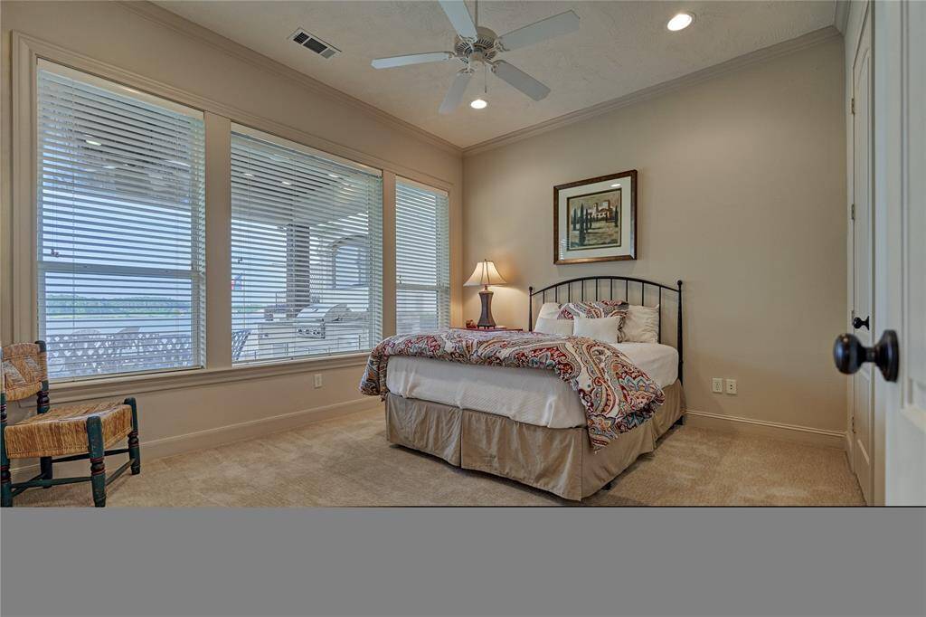 The first floor guest suite enjoys serene lake views and a walk-in closet.