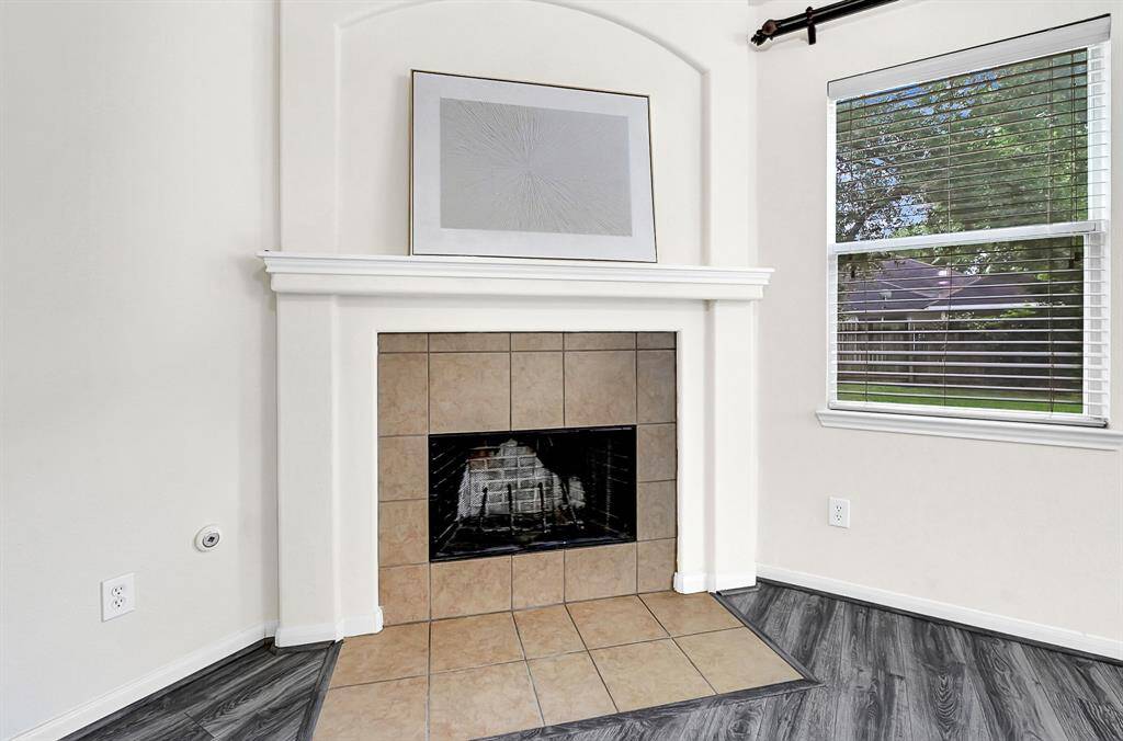 The cozy corner fireplace with tile surround and niche above is the perfect feature for this bright living room.