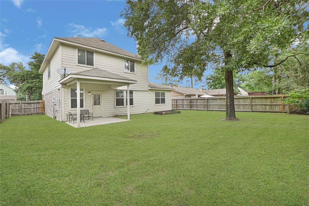 The back exterior of the home showcases the covered patio just off of the breakfast table area. *Grass edited*