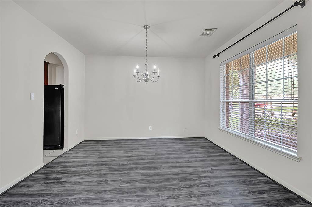 Additional dining room view showcasing the large window allowing plenty of natural light to fill the space and the arched doorway for easy access to the kitchen.