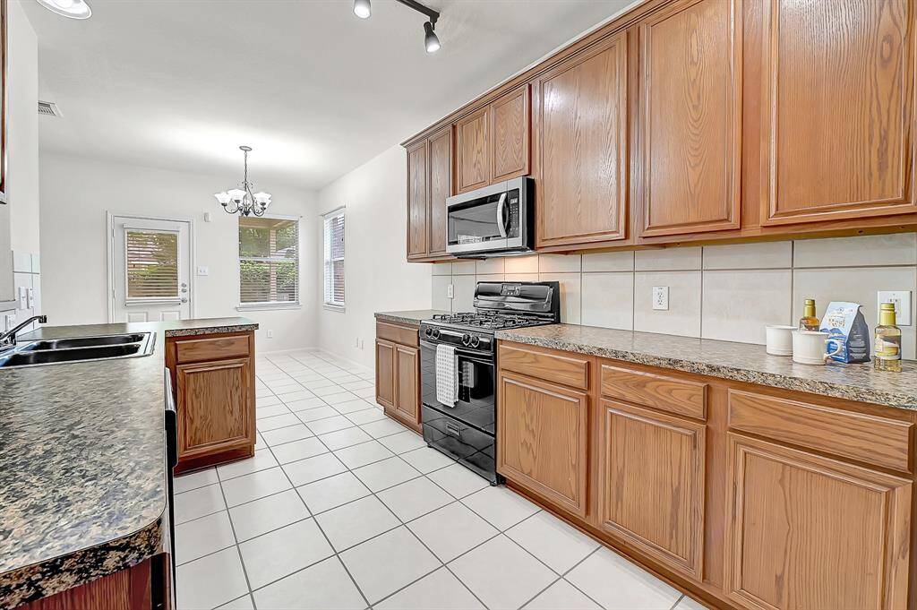 The tiled kitchen features ample cabinetry and counter space for meal-prepping.
