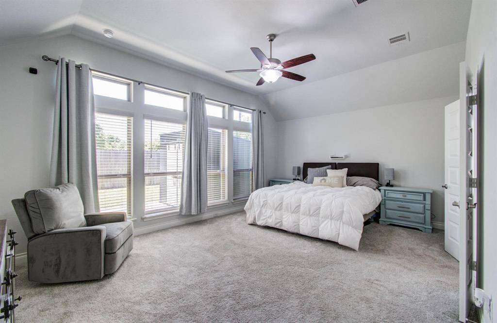 This is the light and bright primary bedroom—spacious and inviting, with plenty of natural light. It connects to a well-appointed en suite bath featuring dual vanities, a soaking tub, a walk-in shower, and a large walk-in closet for ample storage.