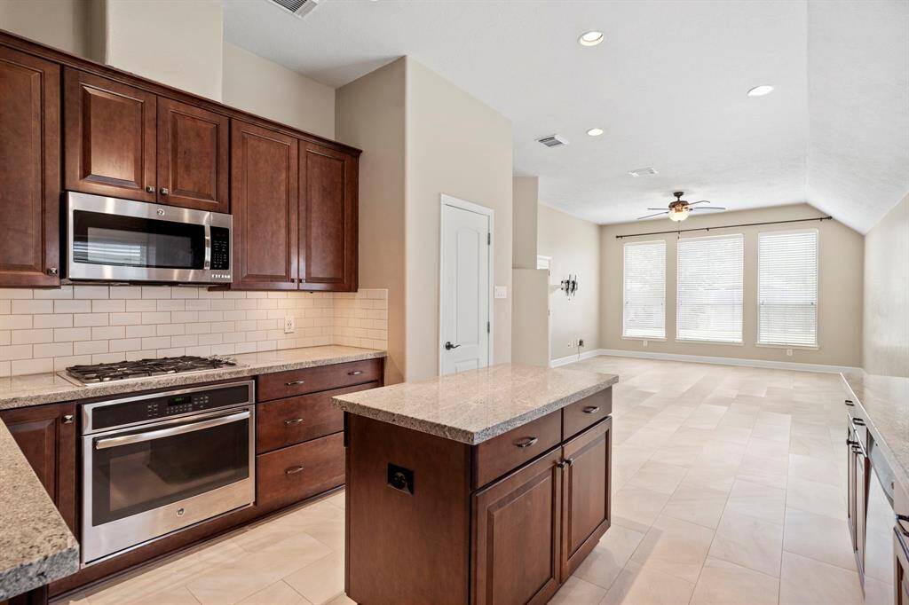 Nice kitchen with center island, granite countertops and subway tile give a cozy feel.