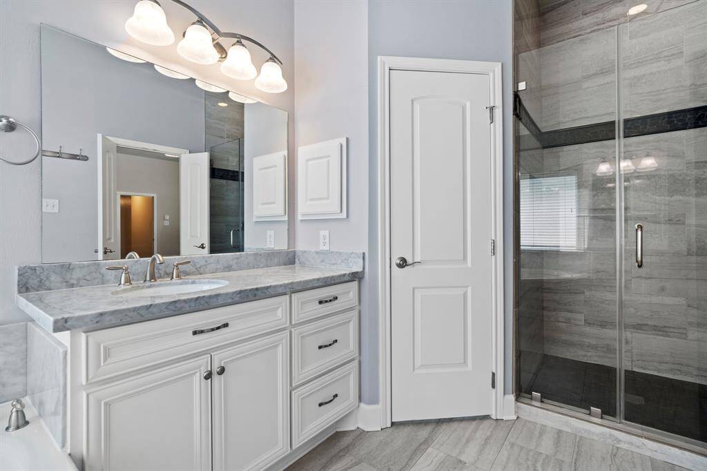 Primary bathroom with separate sinks, marble counter tops.