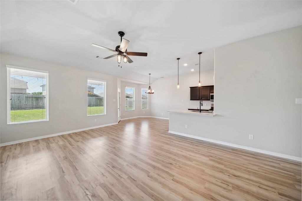 Modern open concept living and dining area with high ceilings, LVP flooring and abundant natural light.