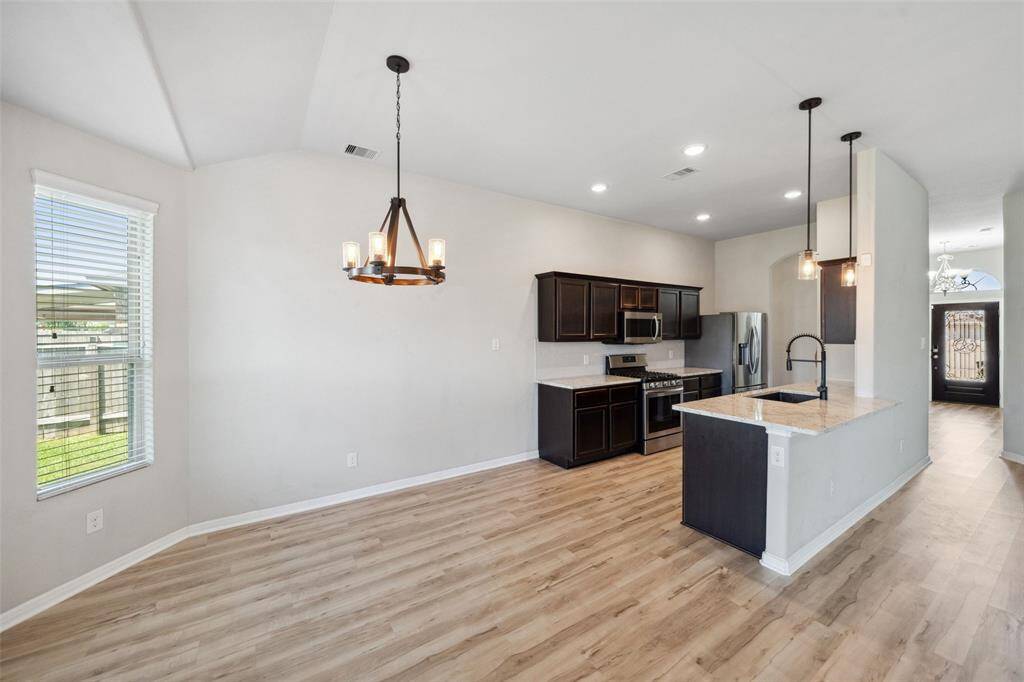 Bright and inviting dining area with large windows and modern LVP flooring, perfect for gatherings and entertaining.