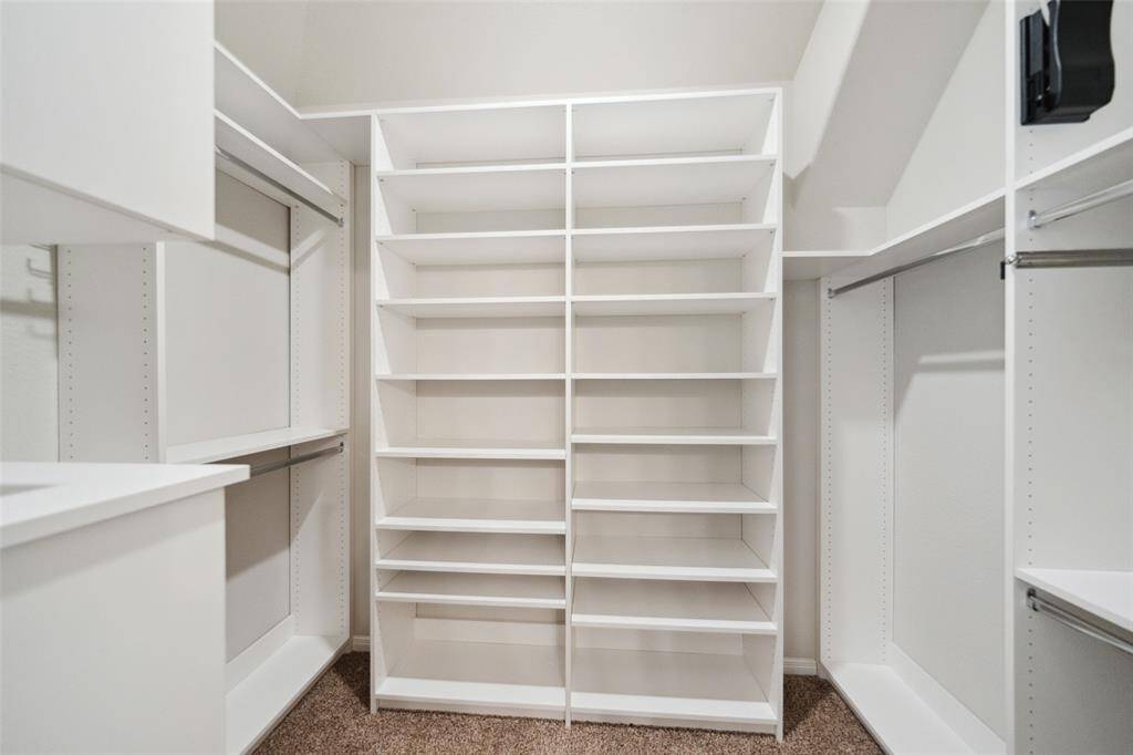 Discover the primary bedroom's custom walk-in closet with elegant built-ins, perfect for organized living.