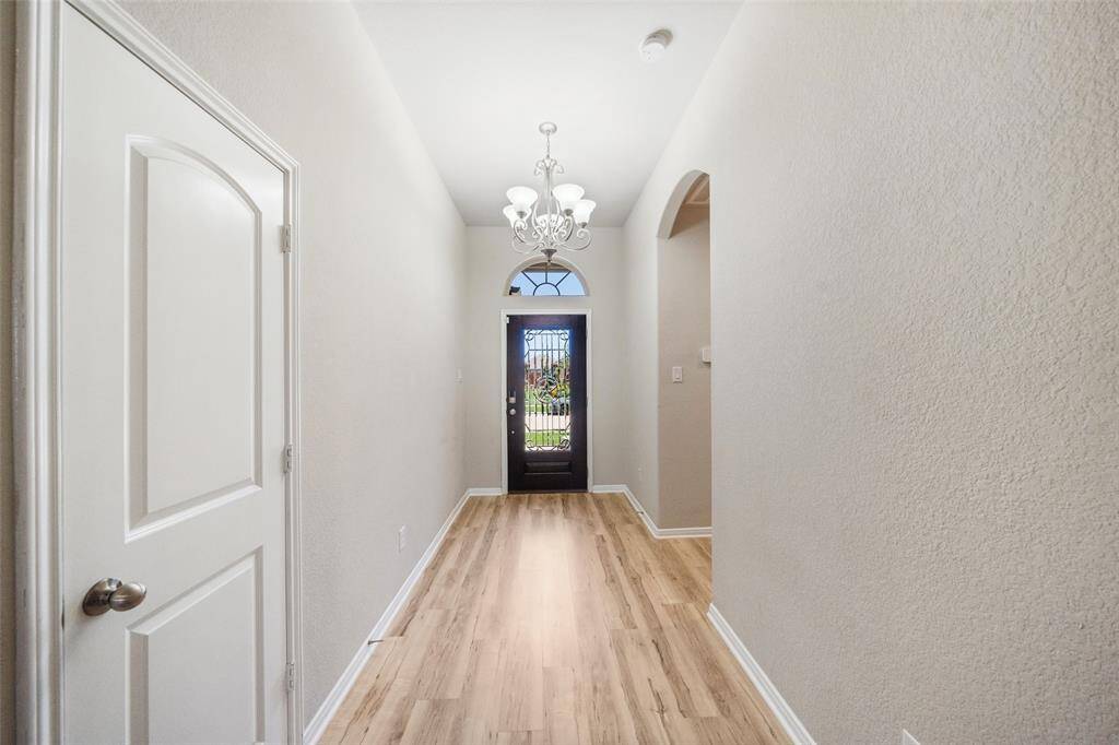 Welcoming entry with a stunning leaded glass door illuminating the space, soaring ceilings, and LVP flooring.