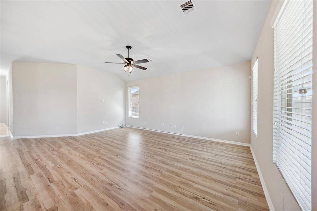 Spacious, light-filled living room with high ceilings and elegant LVP flooring.
