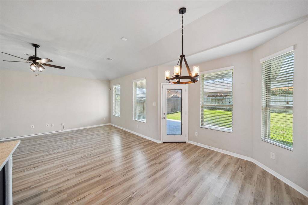 Open dining and living areas with a view of the expansive covered patio and backyard.