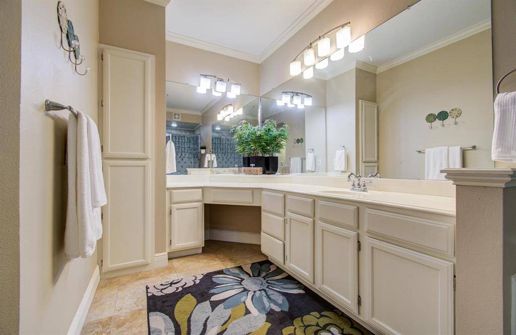 Bathroom features a spacious vanity with ample storage, modern lighting, and a large mirror.