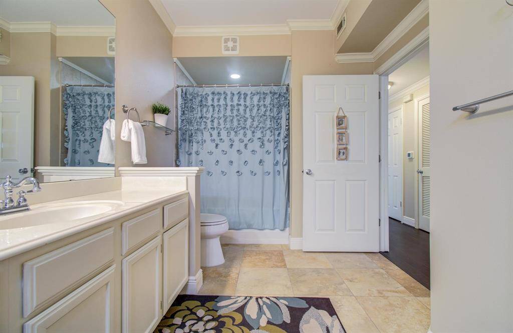 Another view of the bathroom features a double sink vanity with tiled floor.