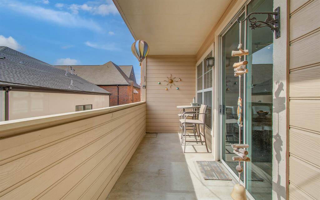 Balcony with outdoor seating area featuring bistro style table and chairs, perfect for relaxing.