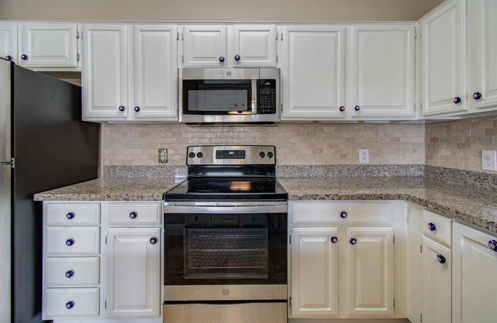 Another view of kitchen featuring electric range with oven, and microwave.