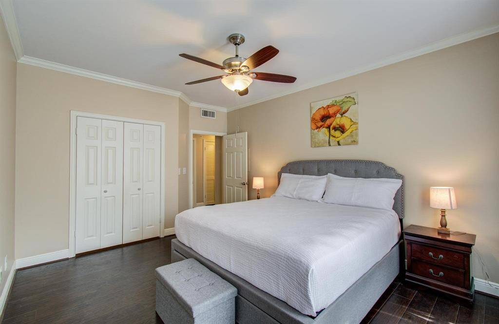 This bedroom offers ample space for a king size bed, neutral walls, ceiling fan, and ample closet space.