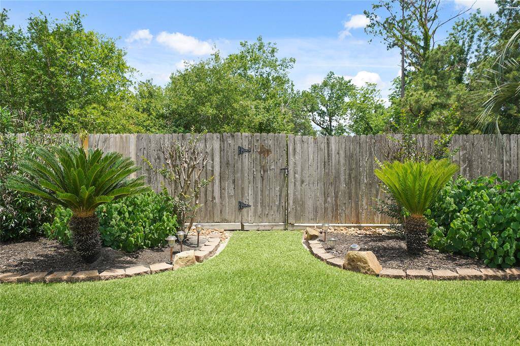 Pictured is a gate that leads to a wooded area behind the home. That's right, no back neighbors!