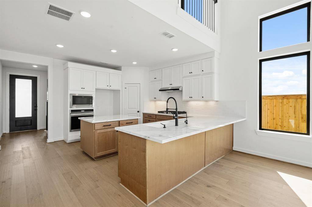 Ample lighting details down to even LED under-cabinet lights, this kitchen is generously bright! Top-of-the-line stainless steel appliances with a BONUS REFRIGERATOR (not pictured). A charming farm-style single bowl silgranit sink with reverse osmosis and a water filtration system included.