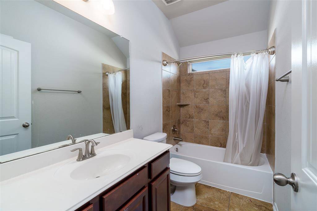 This beautifully designed bathroom features a versatile shower/tub combo, a spacious sink with plenty of counter space for your essentials, and a modern toilet, combining style and functionality for your daily routine.