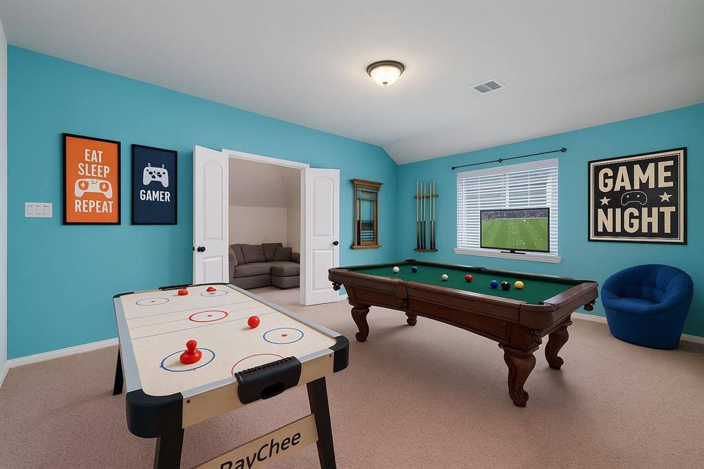 The spacious upstairs game room invites endless fun and relaxation, featuring cozy carpet flooring and soft dome lighting to create the perfect atmosphere for family gatherings or quiet evenings.