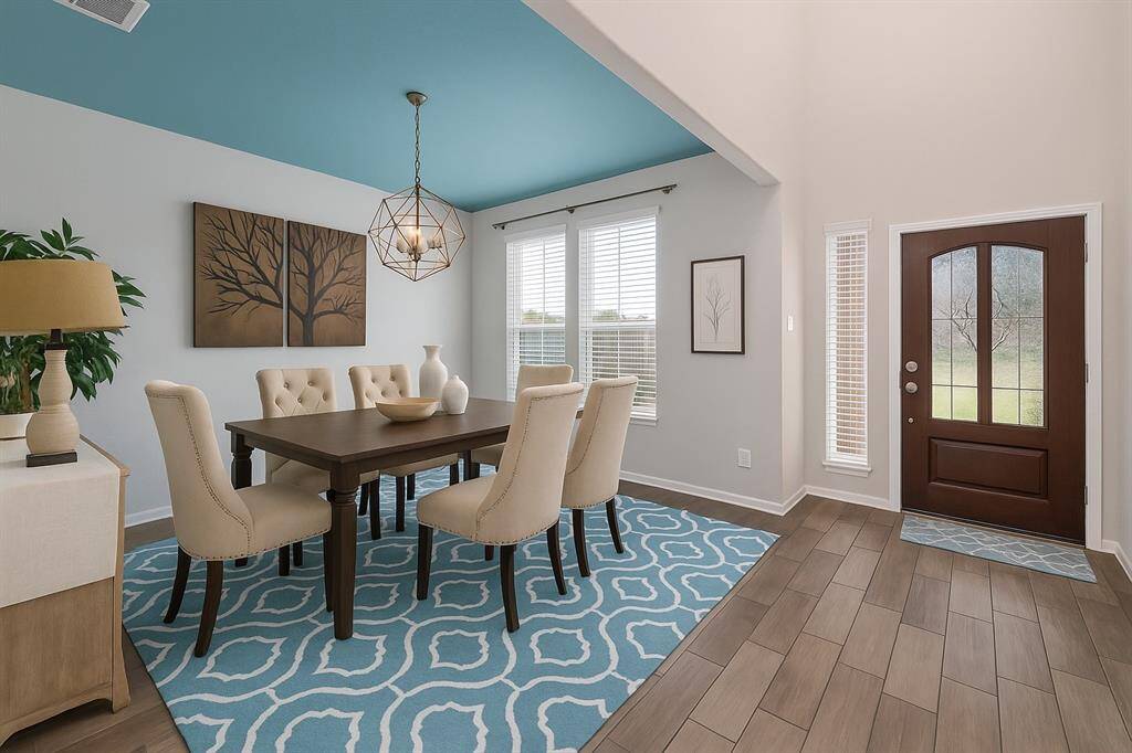 Upon entry, you're welcomed by an elegant formal dining room featuring wood-look tile flooring, stylish privacy-blinded windows, and a striking chandelier that adds a touch of modern charm—perfect for hosting unforgettable dinners.