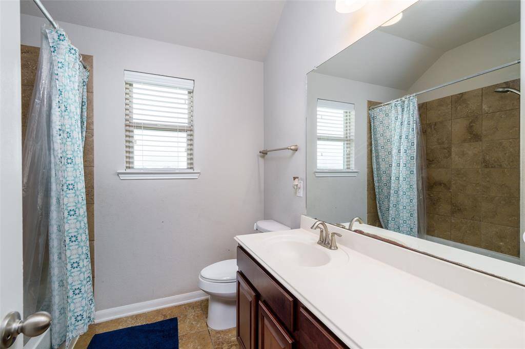 This bathroom offers a convenient shower/tub combo, a sink with ample counter space, and a well-placed toilet for everyday comfort.