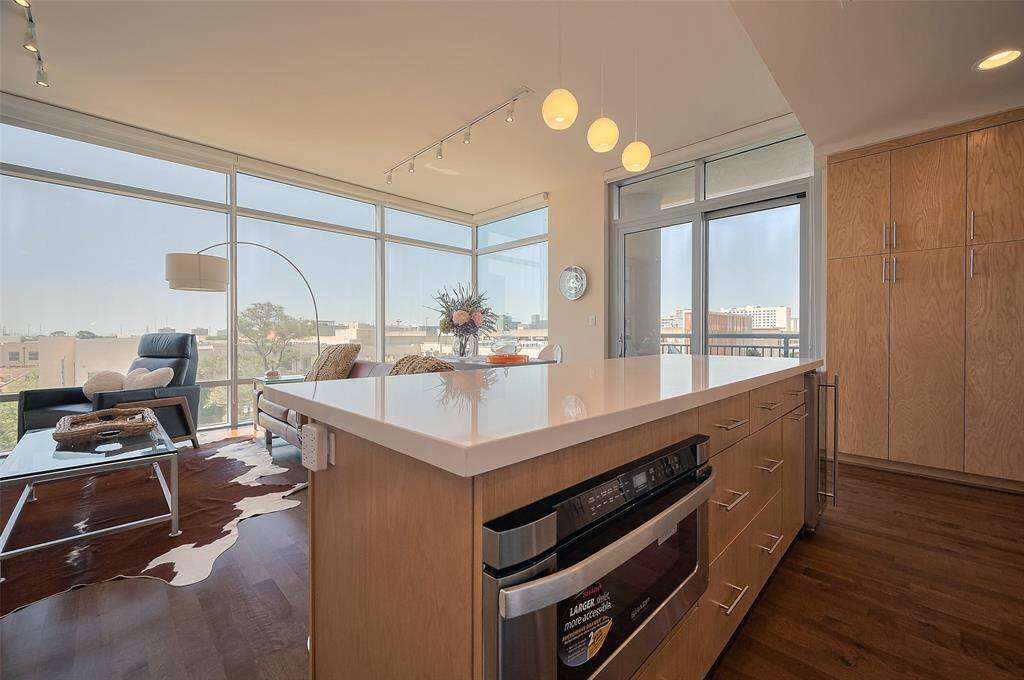 Sleek and modern, this chef's kitchen boasts high-end stainless steel appliances, custom cabinetry, and a generous island that doubles as a breakfast bar.
