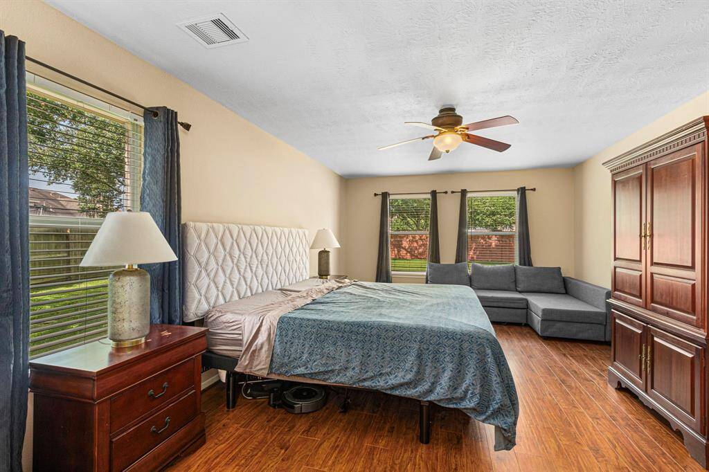 Tucked at the back of the home for added privacy, the master bedroom features wood-like floors and ample space for a sitting area offering backyard views.