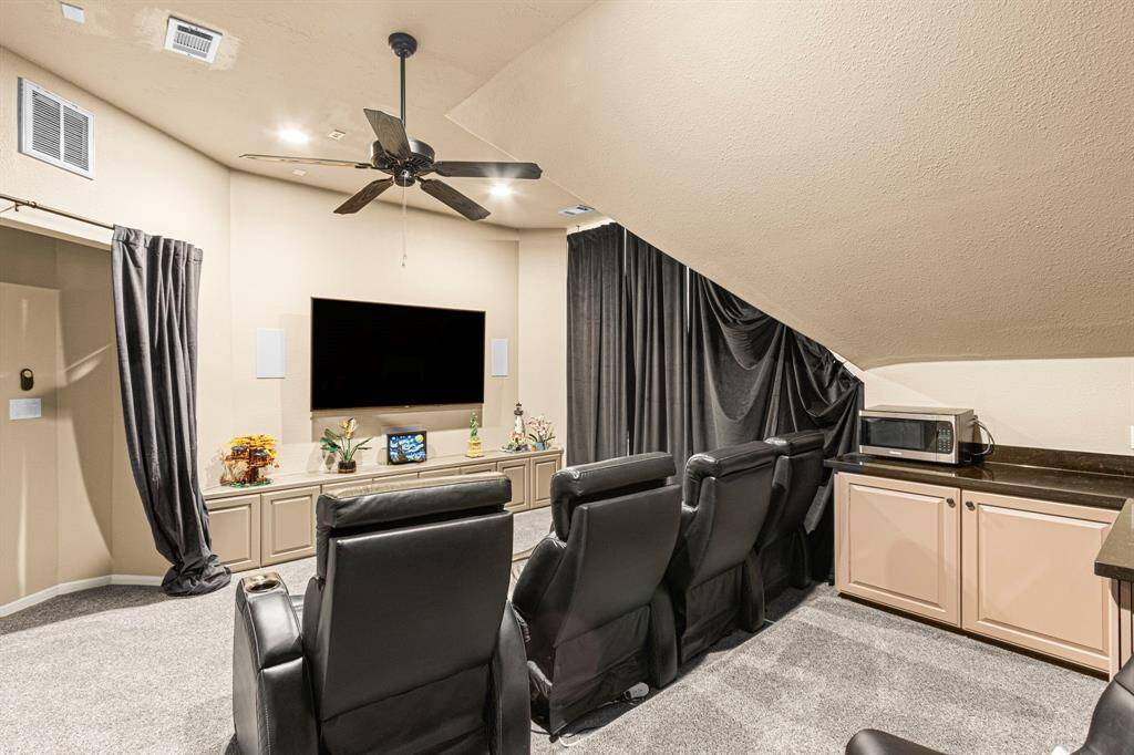 The dedicated media room features built-in cabinetry for seamless storage and display--perfect for housing entertainment systems, games, or a curated movie collection!
