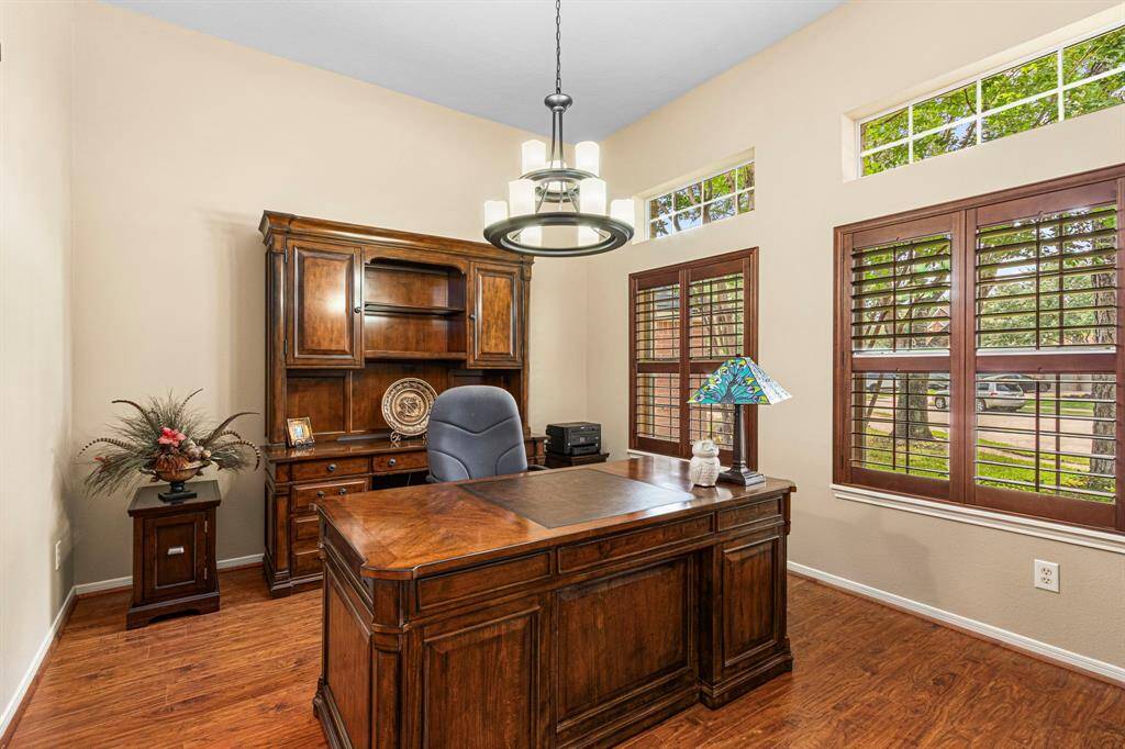 Off the front foyer, the original dining room has been thoughtfully converted into office space. Rich wood shutters add warmth and charm, while allowing for both privacy and natural light.