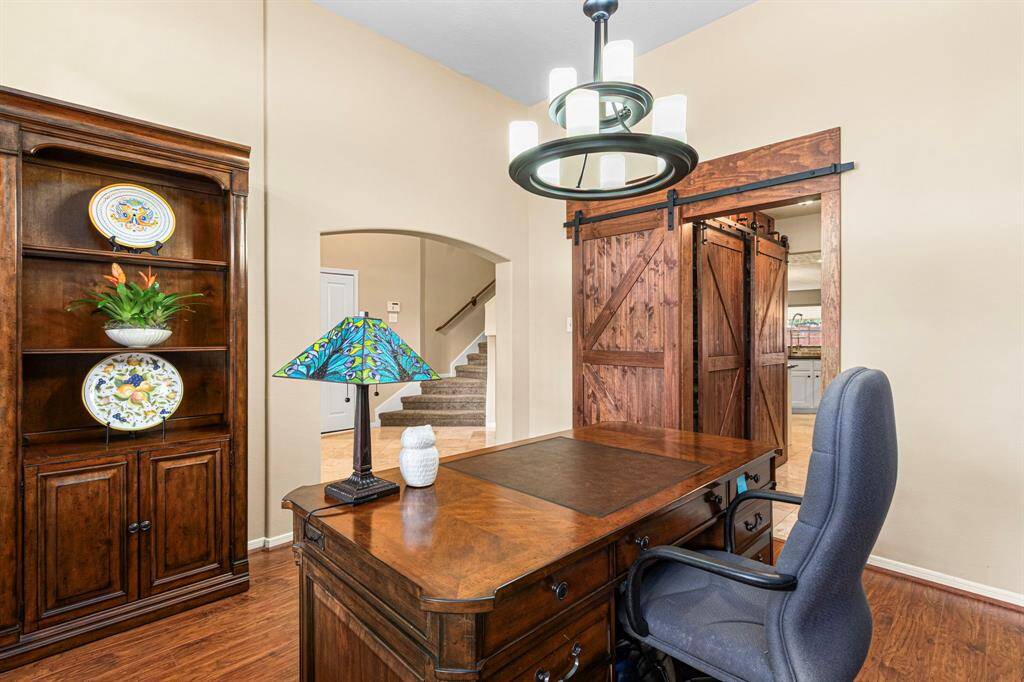 Between office and kitchen, a well-organized hallway hosts a generous pantry with barn doors to one side and laundry room to the other-maximizing convenience w/o sacrificing style or space.