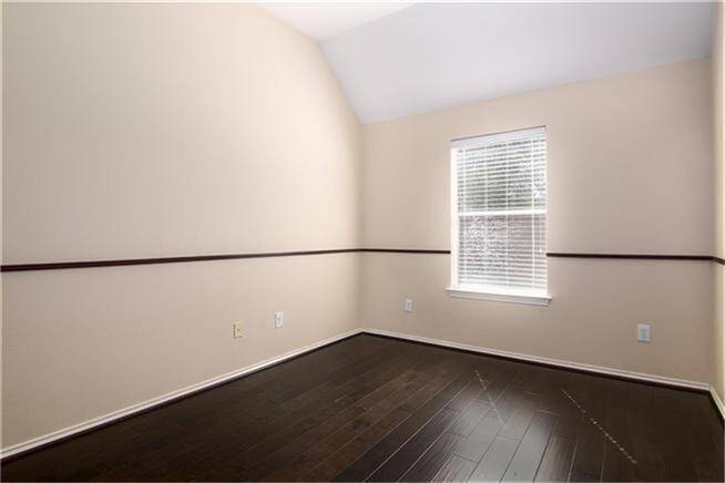 One of the secondary bedrooms with wood flooring.