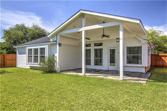 Backyard with a covered patio with ceiling fans, perfect for outdoor relaxation and entertaining.