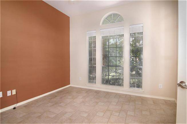 Bright study room/office with large windows and arched transom, offering plenty of natural light.