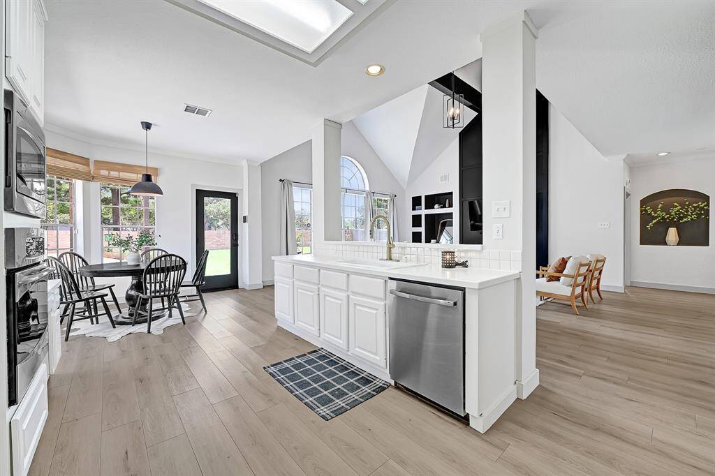 Another angle of the kitchen reveals the sunny breakfast room and abundant natural light, creating a warm and inviting atmosphere.
