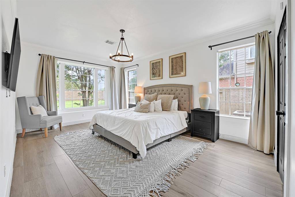 Bright and serene, the primary bedroom features soft white walls and a cozy window seat.