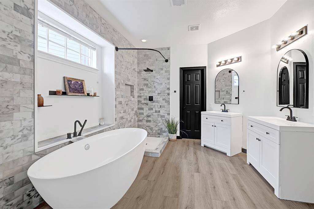Another view of the primary bath highlights the white vanities