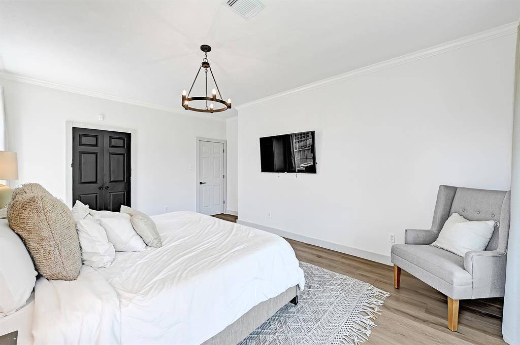 Bright and serene, the primary bedroom features soft white walls and a cozy window seat.