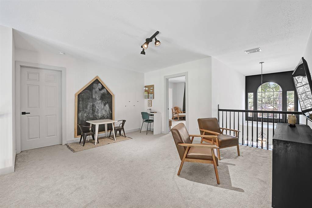 The upstairs gameroom offers a spacious retreat with a view overlooking the family room below, enhancing the home's open and connected layout.