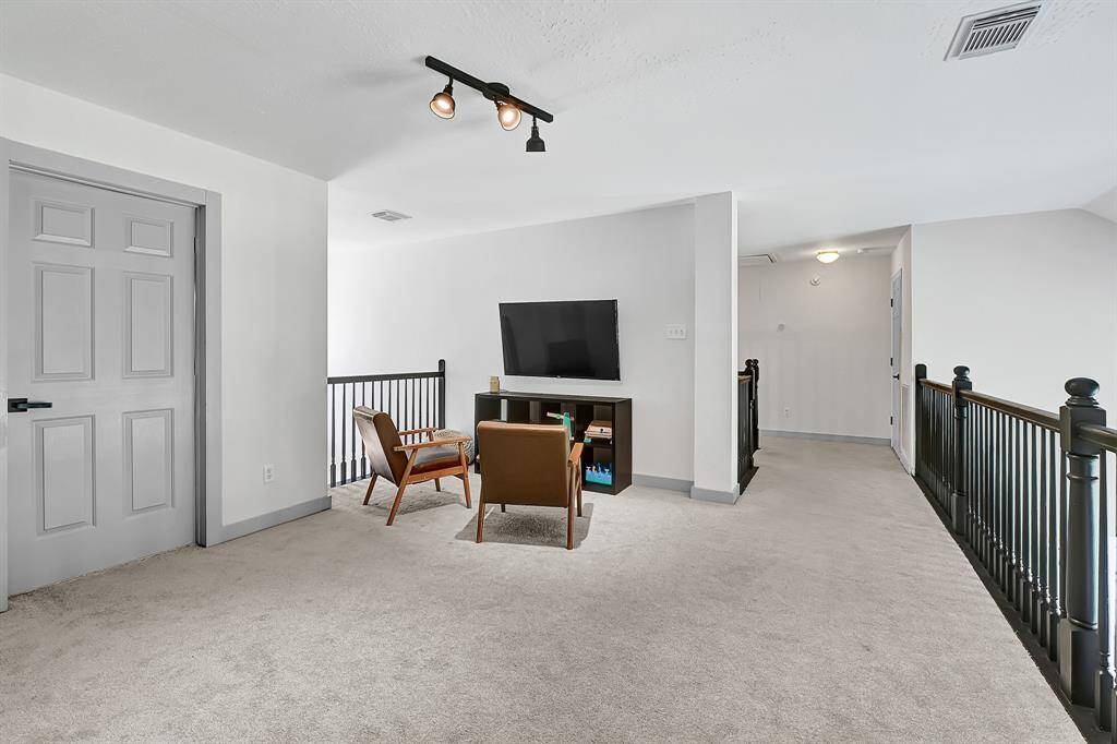 The upstairs gameroom offers a spacious retreat with a view overlooking the family room below, enhancing the home's open and connected layout.