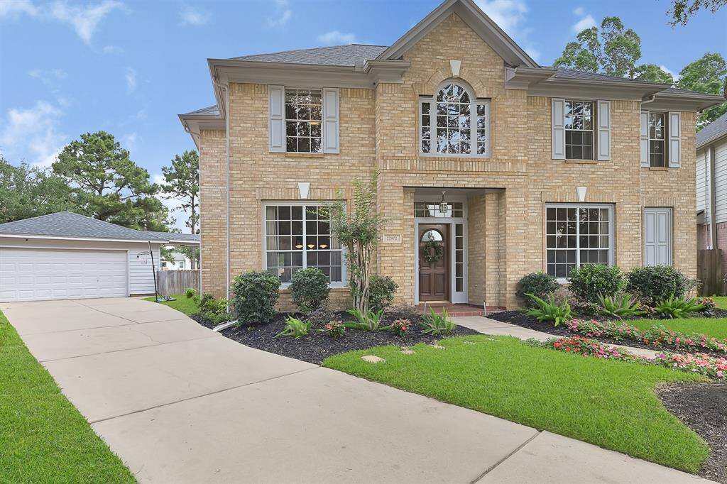 The extended driveway leads to a detached garage, providing ample parking and enhanced privacy.