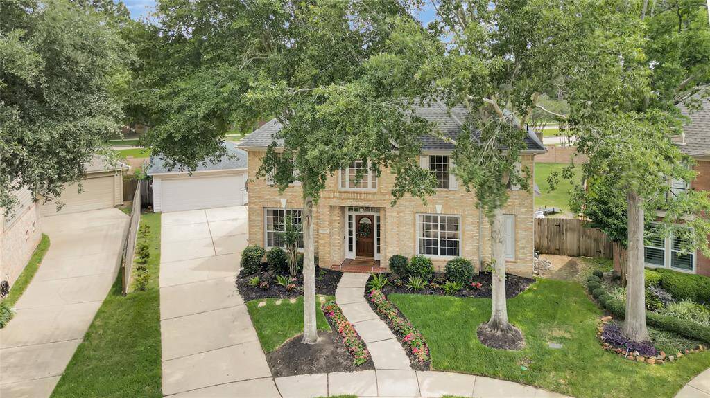 Aerial view captures beautifully manicured oak trees, adding timeless charm and shade to this expansive lot.