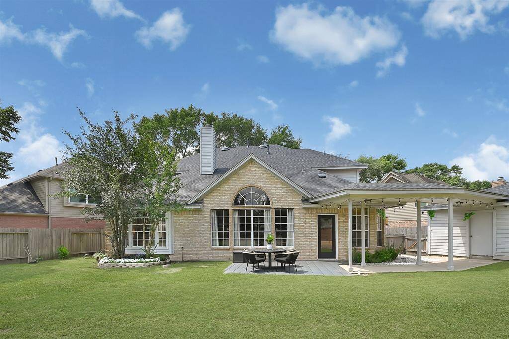 Spacious backyard view looking toward the back of the home, showcasing ample green space and the home's inviting exterior.