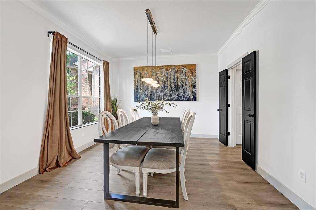Another view of the formal dining room showcases its large front-facing window, filling the space with natural light and a welcoming atmosphere.