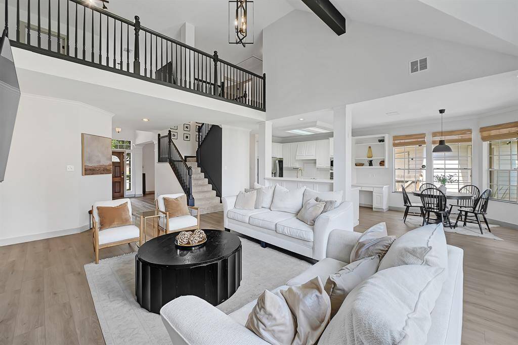 The family room reveals the upstairs gameroom overlooking the space, enhancing the open-concept design and connection between levels.